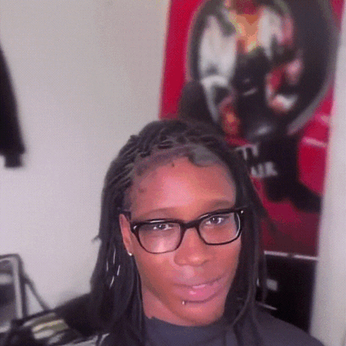 Woman With Glasses And Dreadlocks In Front Of T.I. Air Poster GIF