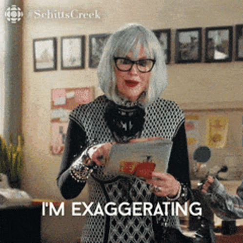 Woman With Glasses and Gray Hair Holding Tablet Saying I'm Exaggerating