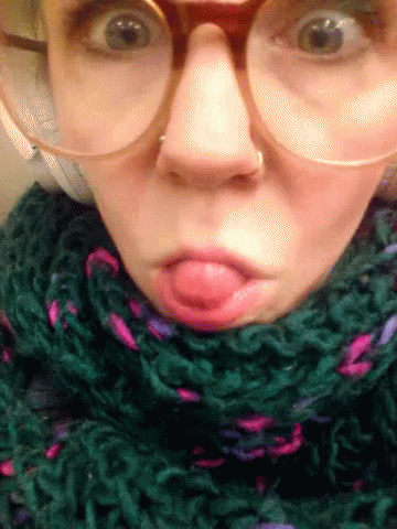 Woman With Glasses and Green Scarf Making Funny Face