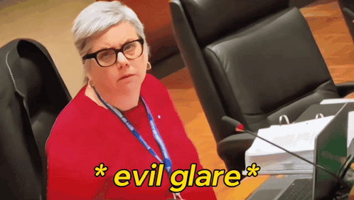 Woman With Glasses and Lanyard Evil Glare