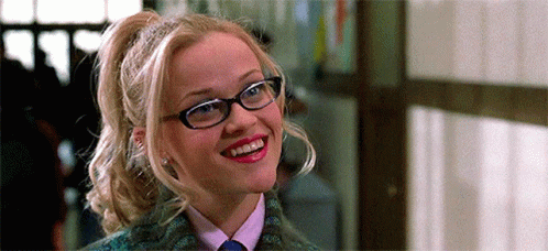 Woman With Glasses And Ponytail Smiling In Tie GIF