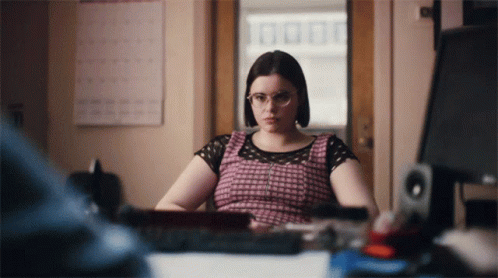 Woman With Glasses At Desk In Front Of Computer GIF