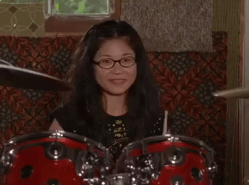 Woman With Glasses Playing Drum Set