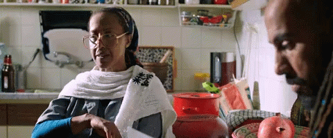 Woman With Glasses Sitting in Kitchen With Man