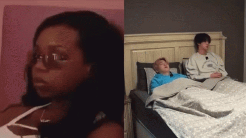 Woman with Glasses Sitting Next to Man in Bed