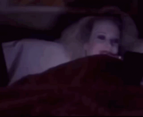 Woman With Glowing Eyes Smiling in Bed