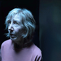 Woman With Gray Hair And Pink Shirt Looking At Camera GIF