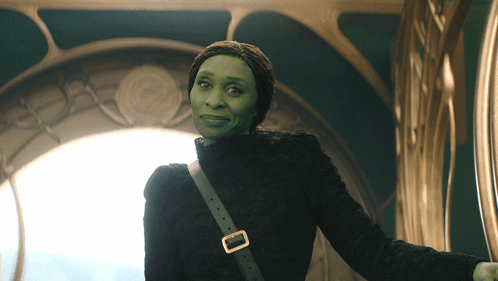 Woman With Green Face And Black Sweater And Shoulder Buckle GIF