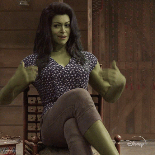Woman With Green Muscles Sitting In Chair Saying Hello GIF