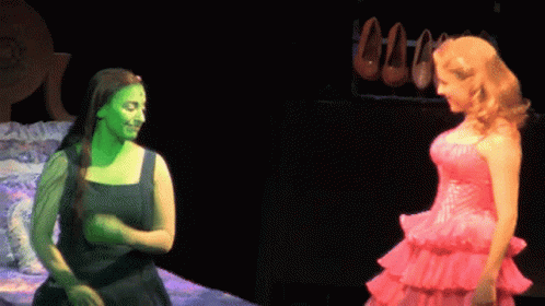 Woman With Green Paint Beside Woman In Pink Dress GIF