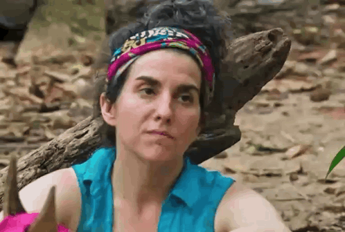 Woman with Headband and Blue Shirt Beside Log in Woods
