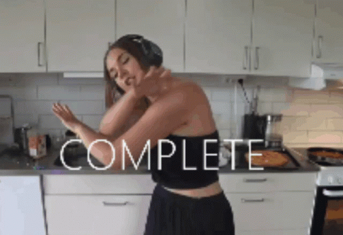 Woman with Headphones Dancing in Kitchen Saying Complete