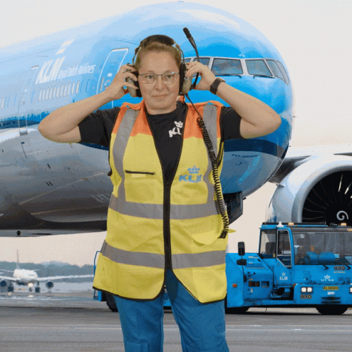 Woman With Headphones in Front of Blue KLM Airplane