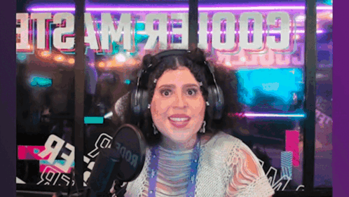 Woman With Headphones Smiling at Microphone With T2 AM on Window