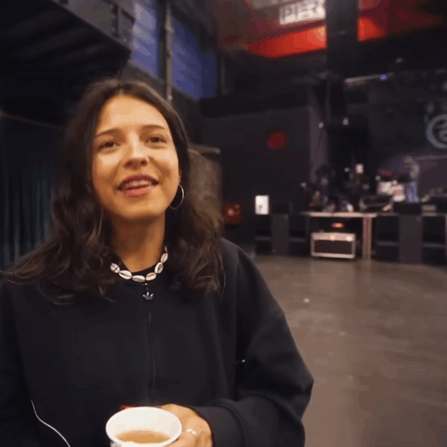 Woman With Hoop Earrings And Necklace Smiles GIF