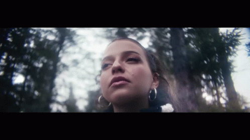 Woman With Hoop Earrings Standing In Woods GIF