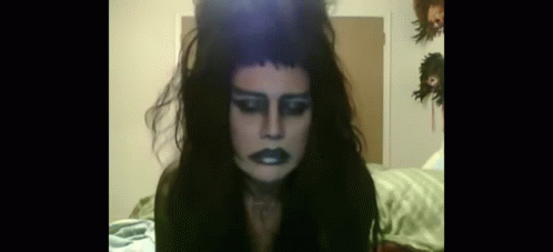 Woman With Long Black Hair and Crown Sitting on Bed
