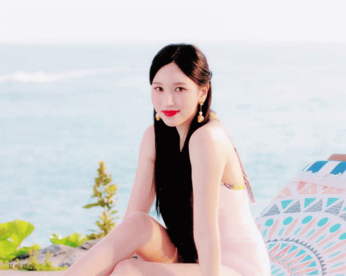 Woman With Long Black Hair Sitting Near Ocean GIF