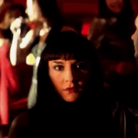 Woman With Long Black Hair Standing In Front Of Crowd GIF