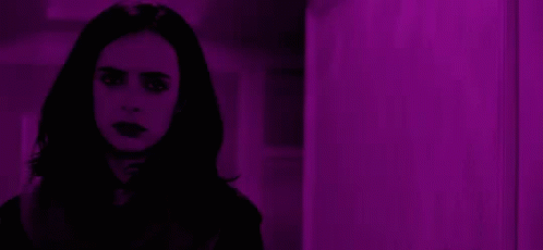 Woman with Long Black Hair Standing in Front of Purple Wall
