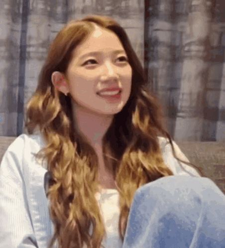 Woman with Long Brown Hair Smiling on Couch
