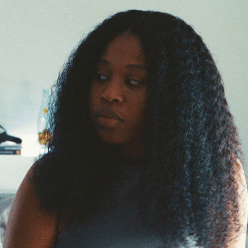 Woman With Long Curly Hair Looking To The Side GIF