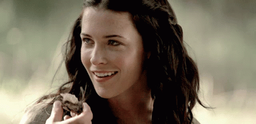 Woman With Long Dark Hair Smiling Holding Food