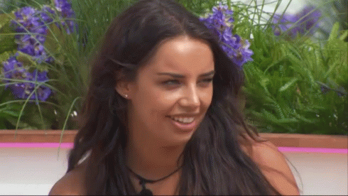 Woman With Long Dark Hair Smiling Purple Flowers GIF