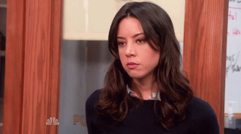 Woman With Long Dark Hair Standing In Front Of Door GIF