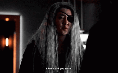 Woman With Long Gray Hair And Eye Bandage Talking GIF