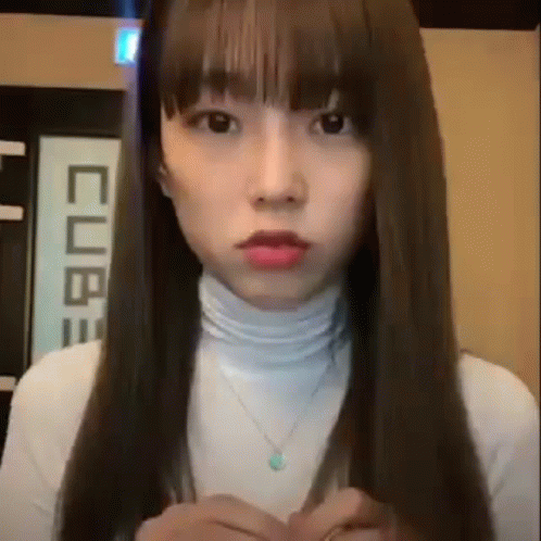 Woman With Long Hair and Bangs in White Turtleneck and Necklace