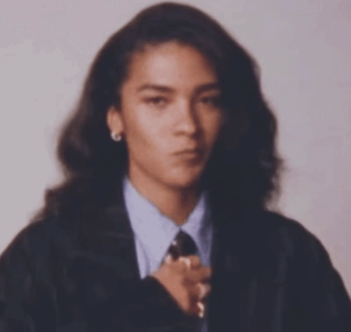 Woman With Long Hair In Suit And Tie Looking At Camera GIF