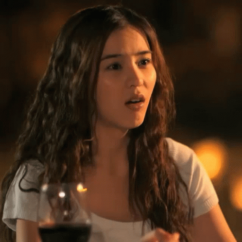 Woman With Long Hair Sitting At Table With Wine GIF