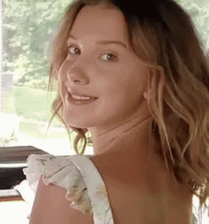 Woman With Long Hair Smiling Over Shoulder GIF