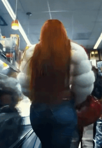 Woman With Long Red Hair In Large White Jacket GIF