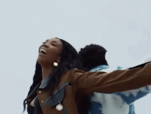 Woman With Necklace And Earrings Beside Man In Blue Jacket GIF