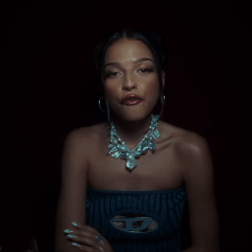 Woman With Necklace And Hoop Earrings Looking At Camera GIF
