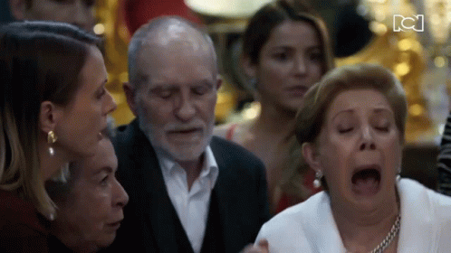 Woman With Open Mouth Surrounded by Group Including Elderly Man