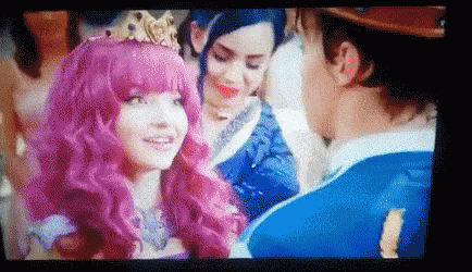 Woman With Pink Hair and Crown Talking to Man in Blue Suit