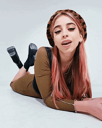 Woman With Pink Hair Laying on Floor Wearing Hat