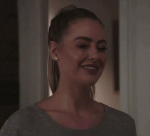 Woman With Ponytail Smiling In Grey Shirt GIF