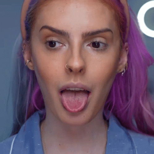 Woman with Purple Hair and Nose Ring Sticking Tongue Out