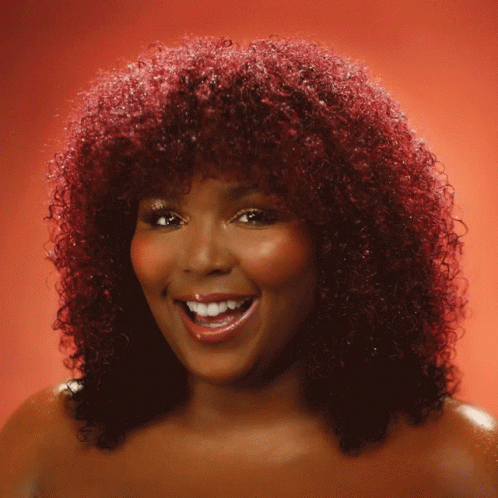 Woman With Red Curly Hair Smiling and Waving