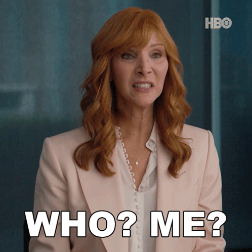 Woman With Red Hair and Pink Jacket Saying Who Me