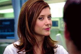 Woman with Red Hair and White Shirt Looking at Man