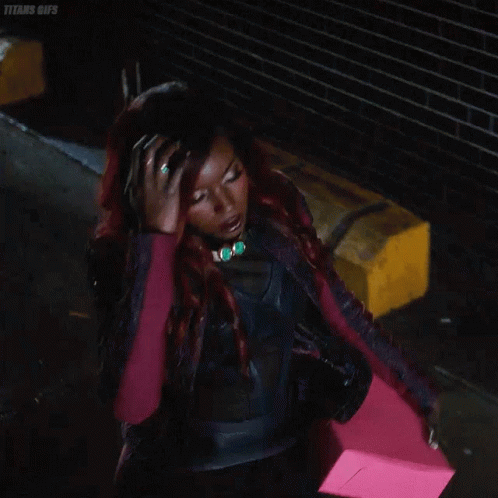Woman With Red Hair In Black Leather Jacket Holding Pink Item GIF