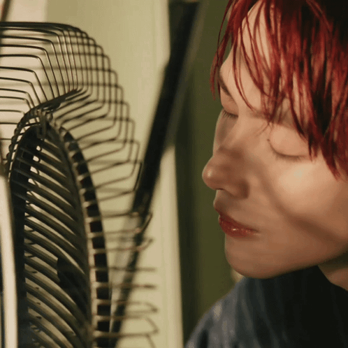 Woman with Red Hair Looking at Fan