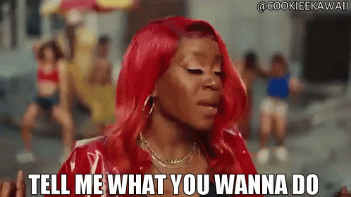 Woman With Red Hair Saying Tell Me What You Wanna Do In Front Of Group GIF