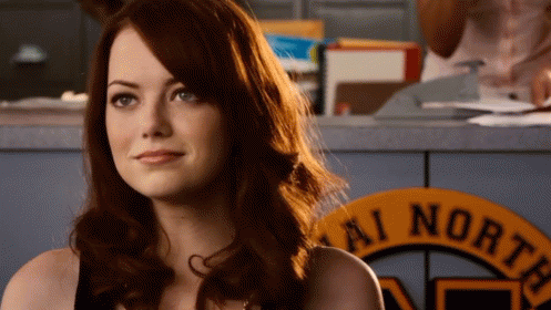 Woman With Red Hair Sitting In Front Of AI North Sign GIF