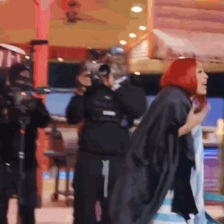 Woman With Red Hair Standing in Front of Crowd